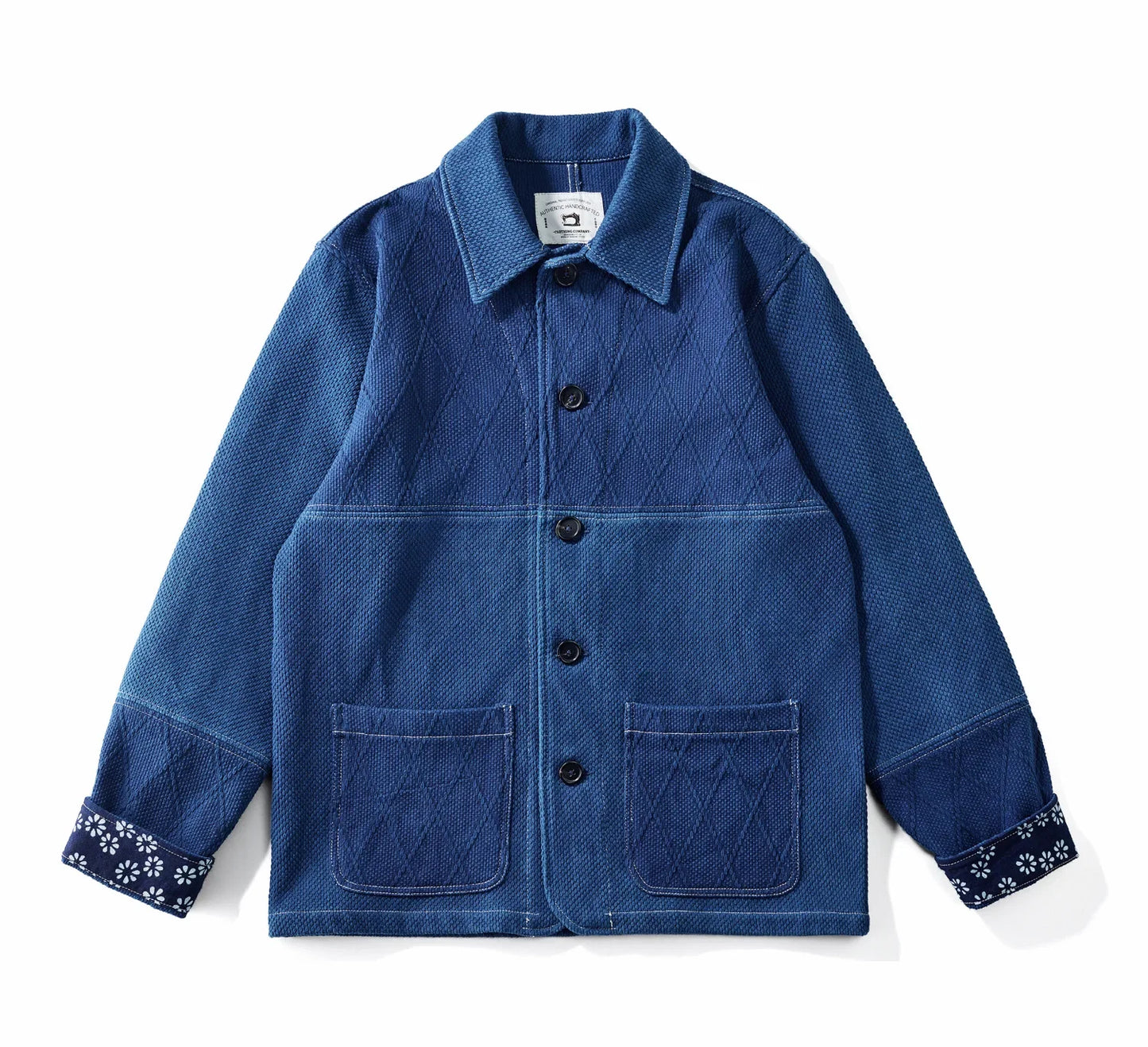 Blue denim jacket with floral cuffs on a white background